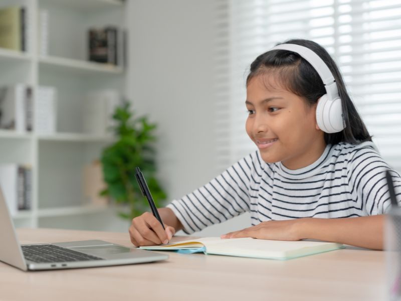 Girl with headphones and laptop learning coding online